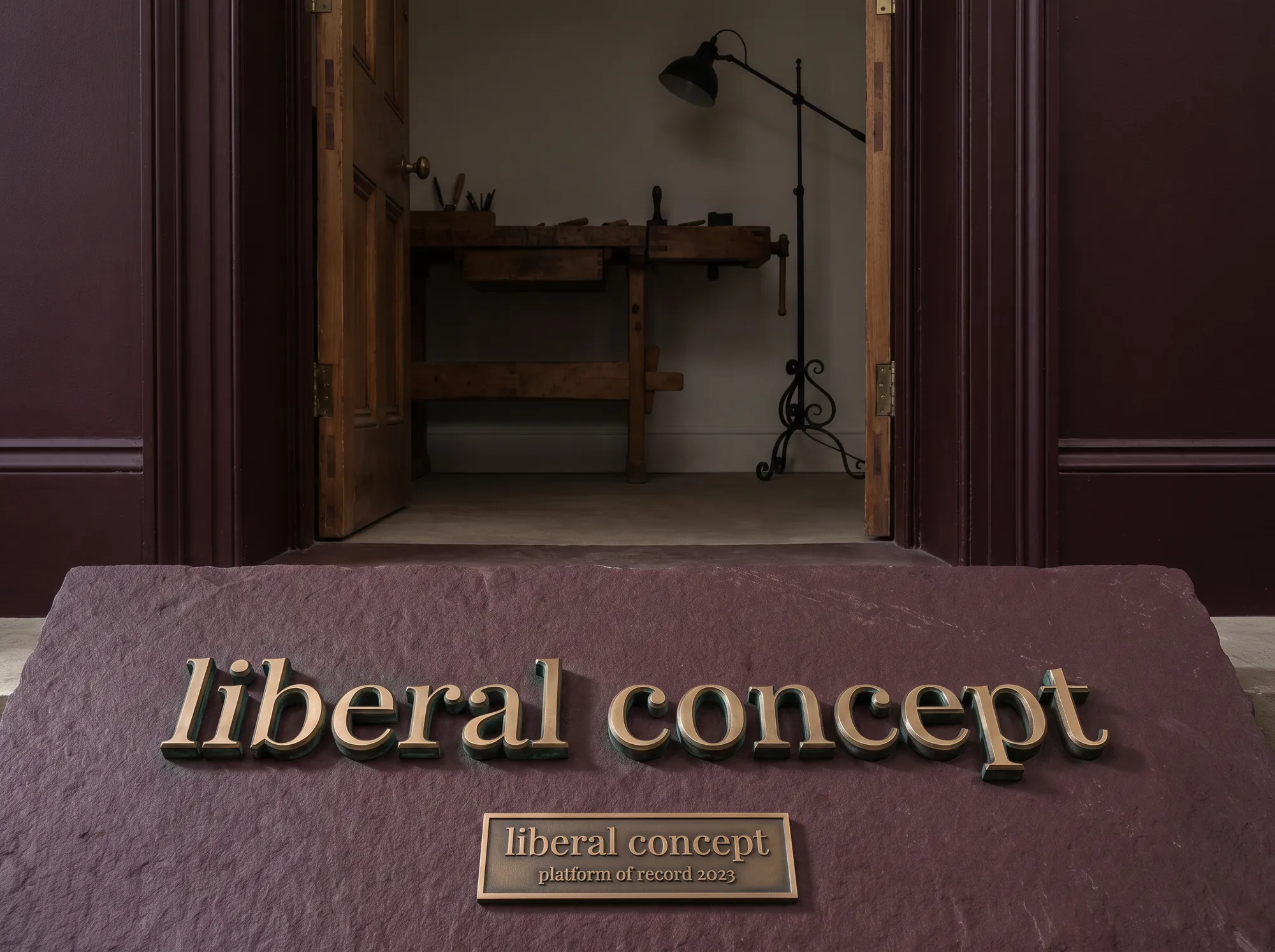 Liberal Concept Platform Door Plaque (Installation) — A working learning-platform office door plaque cast in solid bronze on a deep-wine limestone slab, mounted at the working platform office doorway beside the working studio.