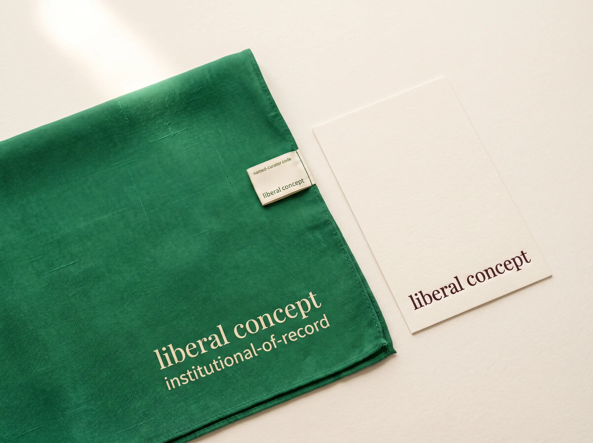 Liberal Concept Cohort Silk Scarf (Museum & Cultural Institution Collaborations) — A long hand-loomed silk cohort scarf in forest green with the wordmark hand-printed in warm cream at one end — a working accessory issued to working institutional members and named curators at the working close.